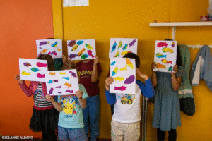 Les adhérents de l'activité Arts plastiques - Petitouts prennent la pose avec leurs dernières œuvres d'art.